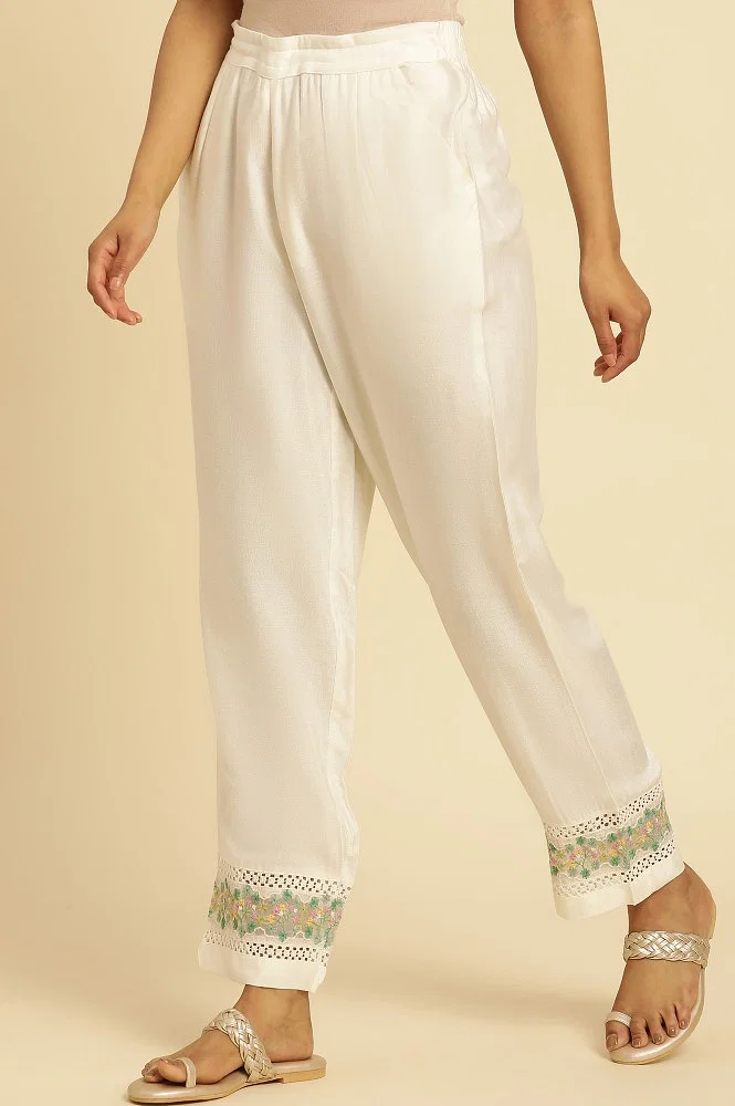 White cotton pants with embroidered detailing at hem by Free Living